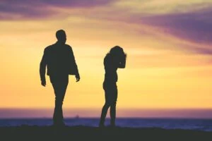 silueta de hombre y mujer bajo cielo amarillo
