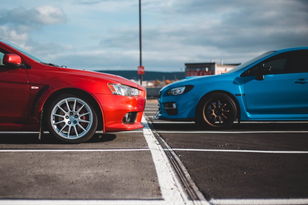 blue and red cars in parking lots
