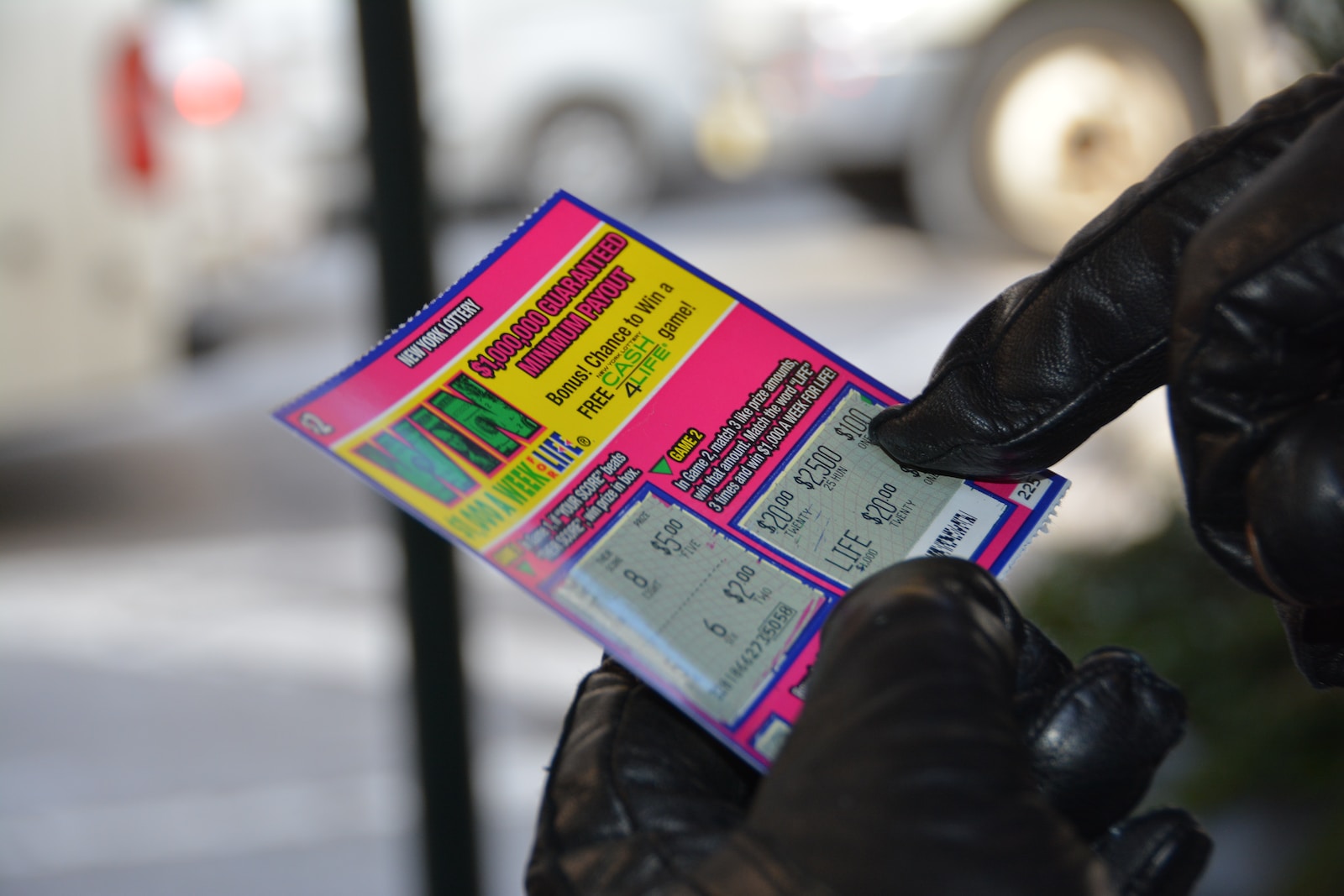 a person in black gloves holding a ticket