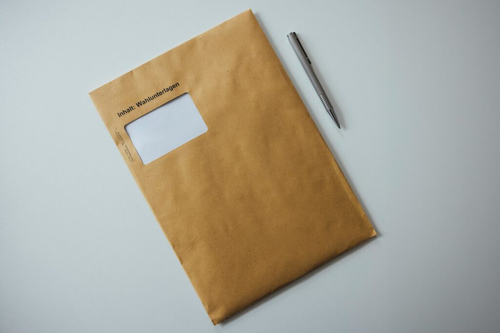 a brown envelope with a pen on top of it