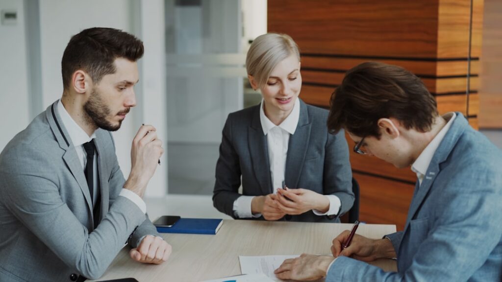 Business people signing a contract at a table. — Photo by Vitaly Gariev on Unsplash