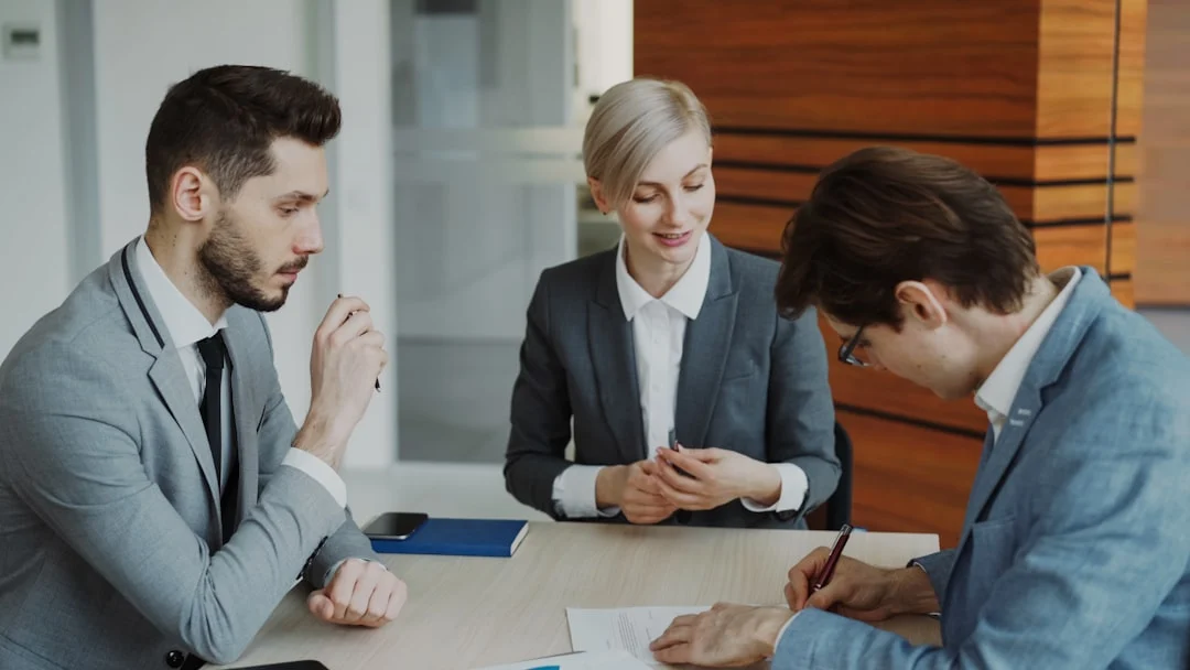 Business people signing a contract at a table. — Photo by Vitaly Gariev on Unsplash