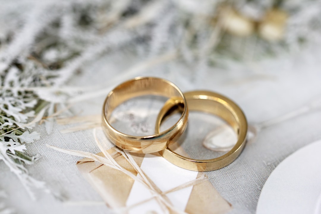gold wedding band on white textile — Photo by Sandy Millar on Unsplash