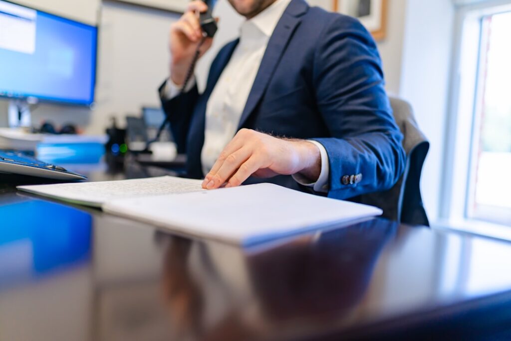 a man sitting at a desk writing on a piece of paper — Photo by Carrie Allen www.carrieallen.com on Unsplash