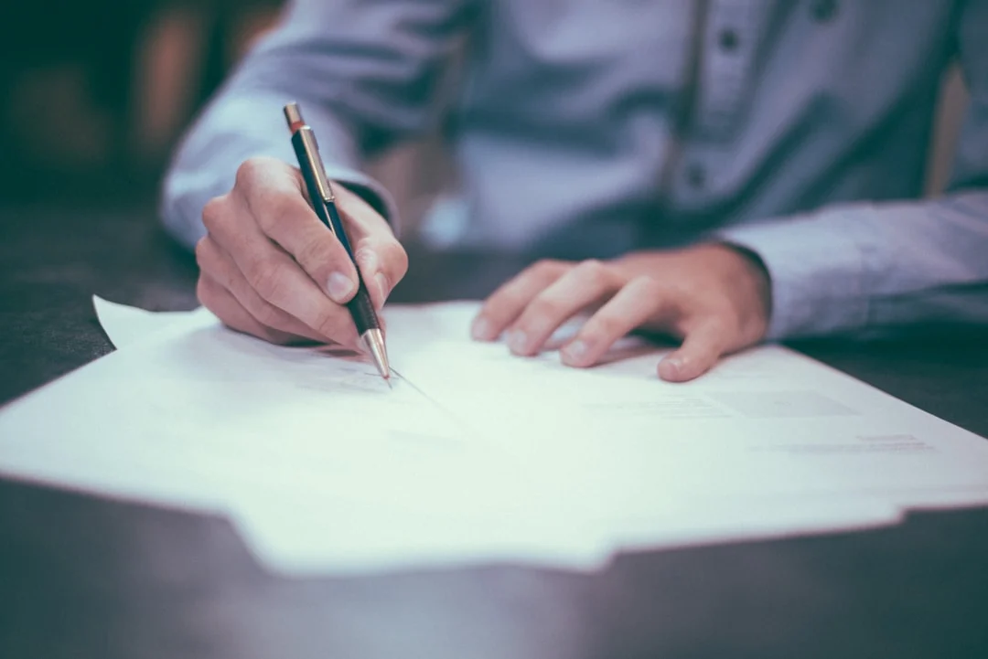 man writing on paper — Photo by Scott Graham on Unsplash