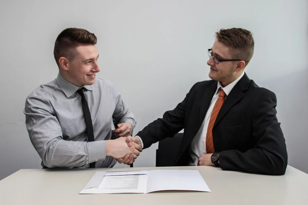 two men facing each other while shake hands and smiling — Photo by Sebastian Herrmann on Unsplash