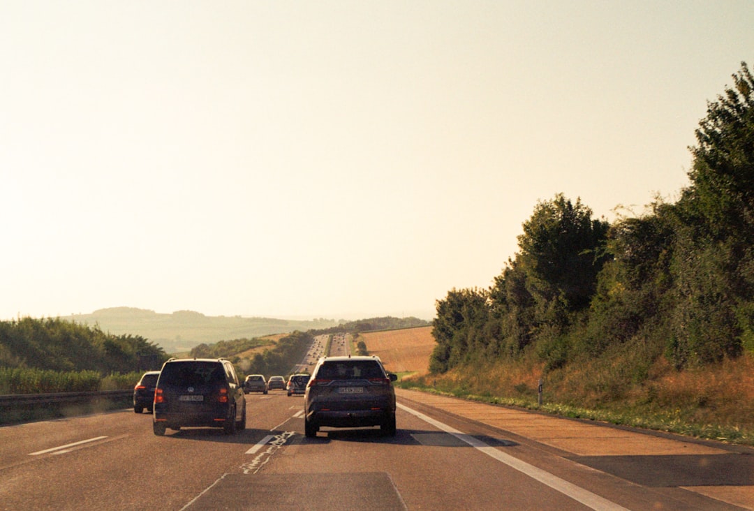 Cars driving on a highway towards rolling hills