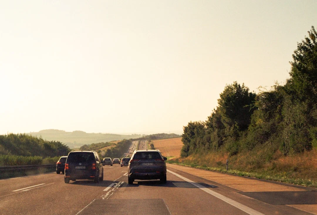 Cars driving on a highway towards rolling hills