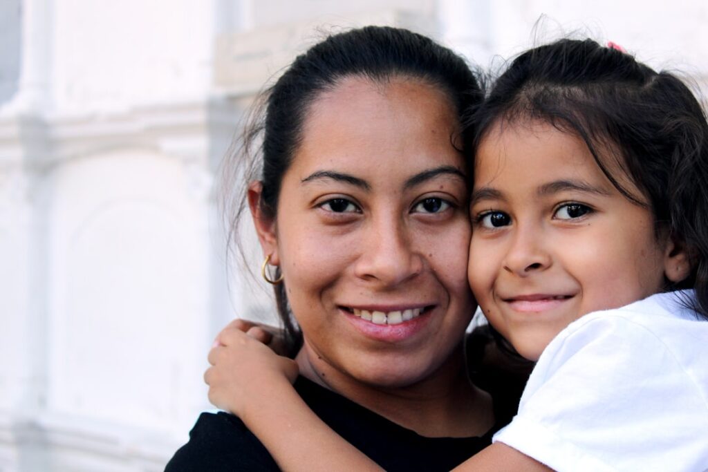 A woman and a child smiling together in a close embrace