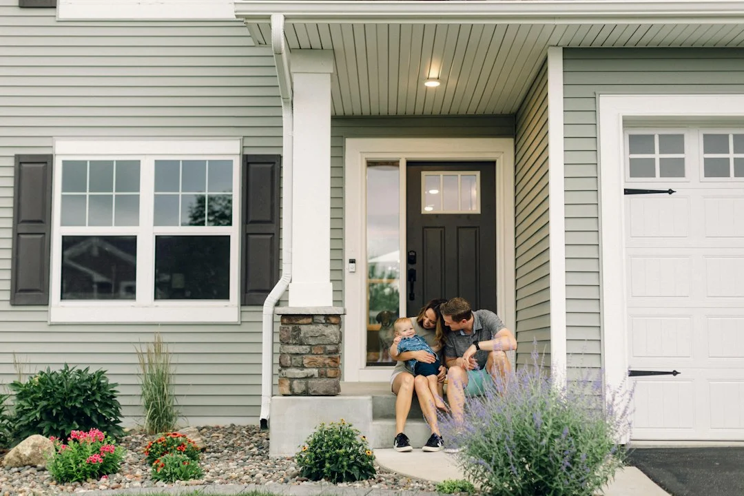a couple of people that are sitting in front of a house
