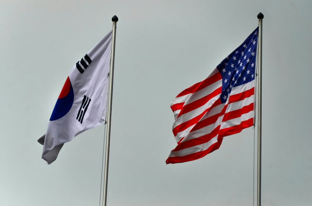 South korean and american flags flying