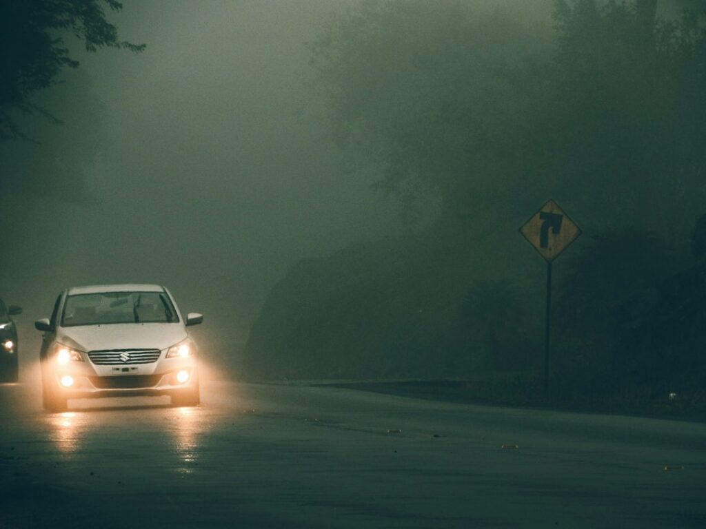a car driving down a road in the rain