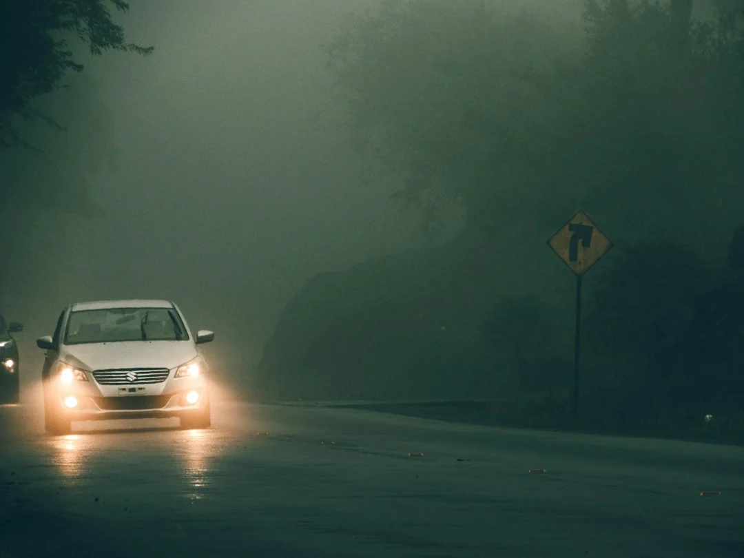 a car driving down a road in the rain